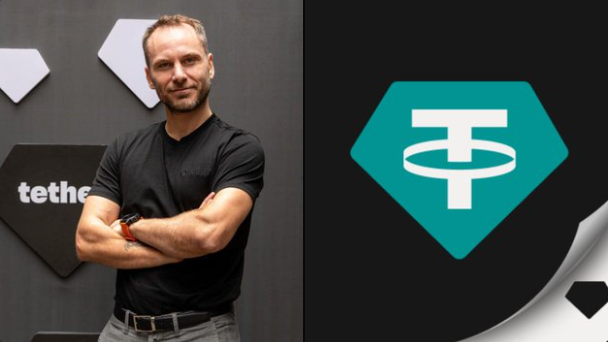 Paolo Ardoino, CEO of Tether, stands with crossed arms in front of the company's branded backdrop featuring its distinctive green hexagonal logo, visually representing the firm behind the strong Q2 financial performance highlighted in the post—$1.5B net operating profit, $4.11B excess reserves, and 146+ tons of physical gold holdings.