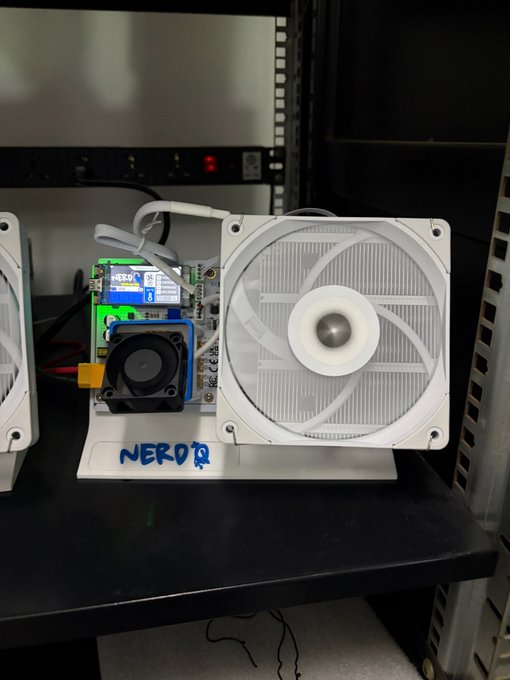 A custom PC build featuring a white case with a large white fan and motherboard mounted on a test bench labeled 'NERDTQ' in blue marker.