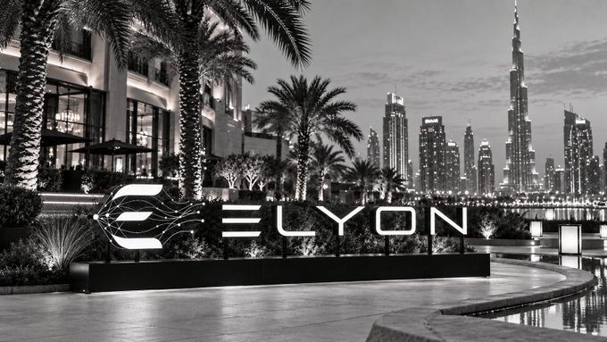 The image showcases the "ELYON" branding logo prominently displayed against a striking black-and-white nighttime view of Dubai's skyline, featuring the iconic Burj Khalifa illuminated in the distance amid palm trees and modern architecture, reflecting the project's ambitious vision of building sophisticated economic infrastructure for Web3. This visual choice suggests Elyon Chain's positioning as a premium, globally-minded Layer 2 network bridging blockchain technology with real-world grandeur and connectivity.