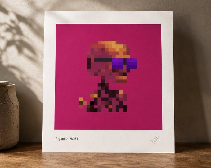 A framed pixel-art print titled "Argonaut #8964" displayed on a wooden surface, featuring a blocky character with blonde hair and purple sunglasses against a vibrant magenta background—showcasing the polished, high-quality digital craftsmanship the post celebrates from artist @lphacentaurikid.