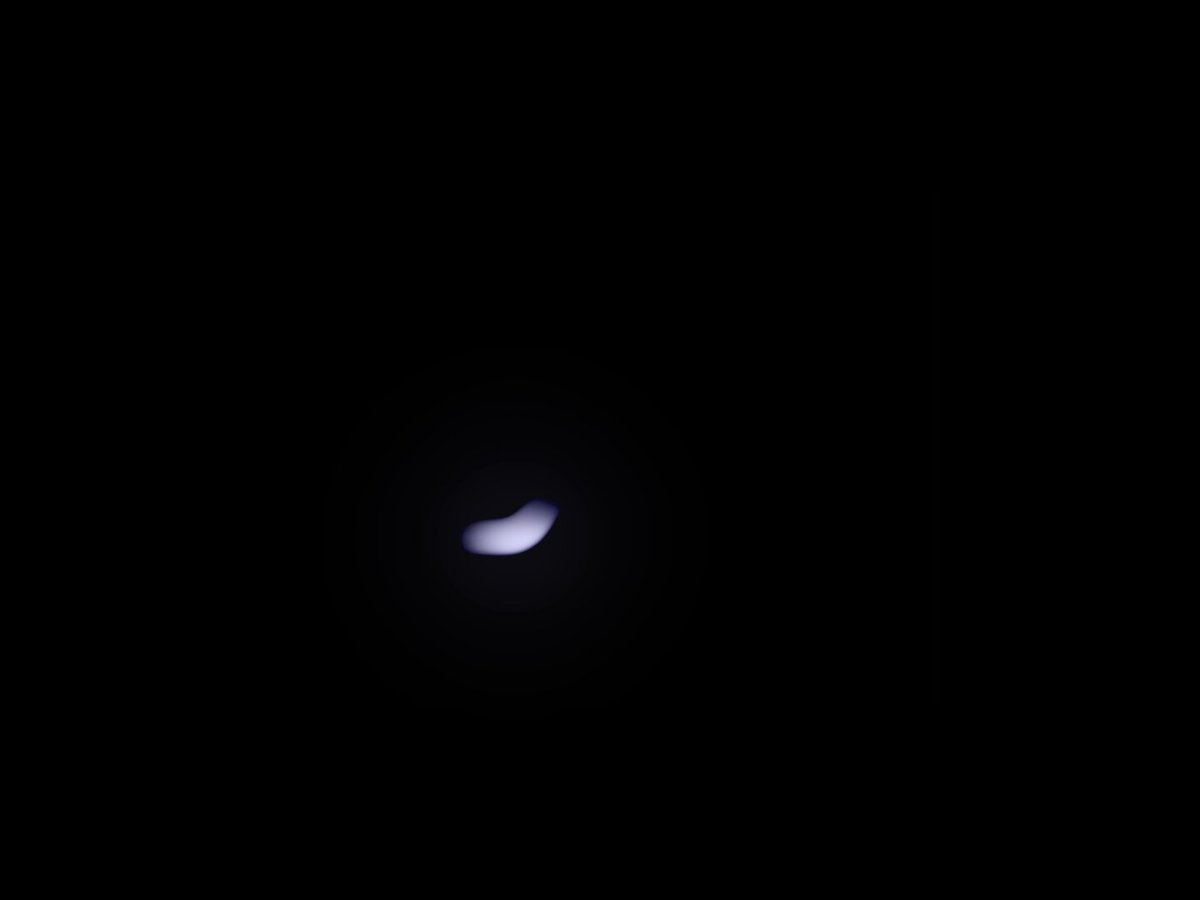 The image features a small, glowing dot in the center of a black backdrop with a large white border around the entire scene. This dot appears to be floating in space or emitted from an object at a very high speed, as if captured by a camera's shutter release motion mechanism. The white border surrounding the dot creates a sense of contrast and draws attention to the focal point of the image. There is no text present on this image, so it does not provide any meaningful information about its source or context.