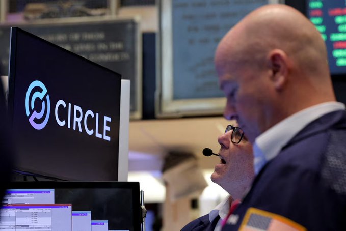 A trader works on the floor of the New York Stock Exchange beside a monitor displaying the "CIRCLE" logo, with the company's name clearly visible amid the trading screens. The scene captures the tense atmosphere surrounding Circle's volatile post-earnings trading session, visually reflecting the market's uncertainty and indecision highlighted in the accompanying commentary.