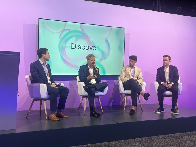 Four panelists sit on stage at the Sibos conference, engaged in discussion in front of a large screen displaying the word "Discover" against a pastel gradient backdrop, reflecting the post's focus on the future of connected, interoperable finance across public and private chains.