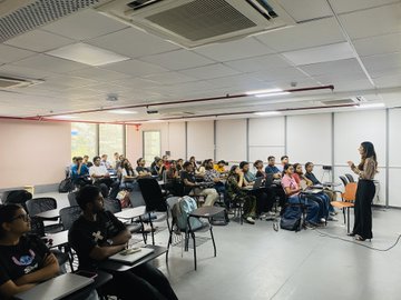 A speaker presents to a packed classroom of young attendees seated in tiered rows, sharing insights about creator payouts, giveaways, hackathons, and bounties—highlighting the growing enthusiasm and curiosity among India's emerging builder and creator community.

No specific text, numbers, or names are visible in the image.