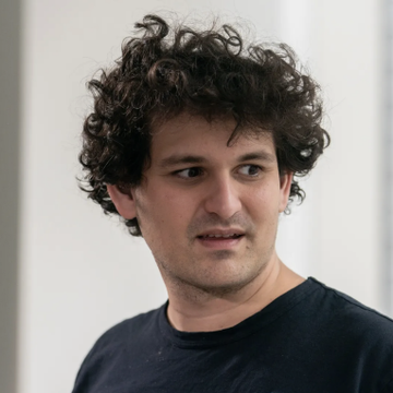 A man with curly dark hair wearing a black t-shirt is pictured in a close-up portrait, his expression appearing serious and contemplative as he looks off to the side. The image relates to the news of Sam Bankman-Fried's appeal to the Supreme Court for a new trial and to overturn the $11 billion forfeiture order following his fraud conviction.