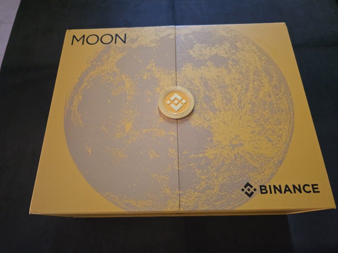 A yellow box with a textured moon design and the word "MOON" branded with the Binance logo.