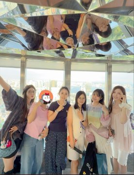 A group of six stylish women pose together inside a mirrored installation, with their reflections visible on the reflective ceiling above, matching the post's mention of gathering with "top beauties" at what appears to be a Memecore event.