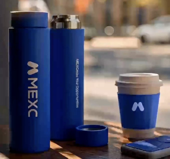 Three blue MEXC-branded beverage containers, including two water bottles and a coffee cup with sleeve, arranged on a wooden surface with the text 'MEXC: Your Opportunities'.
