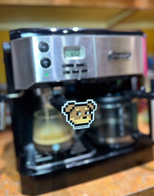 A stainless steel espresso machine, with a pixel art dog sticker overlaid on the image, actively brewing coffee into a glass carafe.