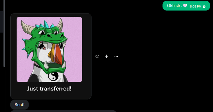 A chat message showing a cartoon dragon emoji wearing a yin-yang shirt with the caption "Just transferred!" and a response bubble reading "Okh sir. 🤍" timestamped 8:03 PM, accompanying a post about receiving an awesome gift and celebrating creative success.