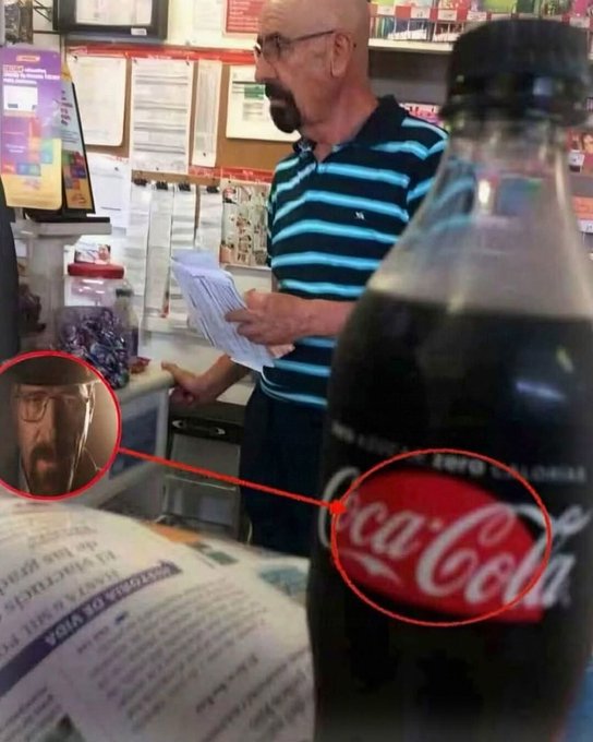 A bald man in glasses and a blue striped shirt holds papers in a convenience store, with a magnified inset highlighting a resemblance between his face and the Coca-Cola logo on a bottle in the foreground.