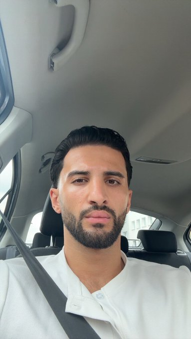 A man with a beard wearing a white shirt takes a selfie in his car, posting "GM / Gmonad" ahead of the @Gloombles NFT mint the following day, expressing his long-anticipation for the drop.
