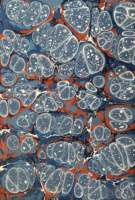 An abstract artistic pattern featuring blue, white, and orange marbled shapes that resemble cellular or organic structures.