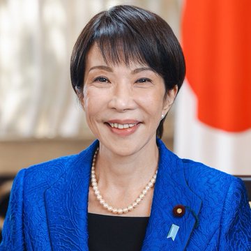 The image features an older woman wearing a blue jacket with a pearl necklace. She has short hair and is smiling at the camera, giving off a warm and approachable vibe. The background of the photo shows a flag from Japan, which suggests that this could be related to a discussion about the Japanese economy or financial matters in general.

The image also contains text that reads "BREAKING: JAPAN TO ALLOW BUSINESSES TO USE DRC FOR INSTANT FOREIGN SETTLEMENT" and "focus on what is in the image and how it relates to the post". This could be a promotional piece for a new stablecoin or an article discussing the potential benefits of using stablecoins for international transactions.