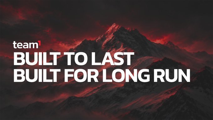 A dark, dramatic promotional image with a red-tinted mountain landscape background and the text 'team1 BUILT TO LAST BUILT FOR LONG RUN'.