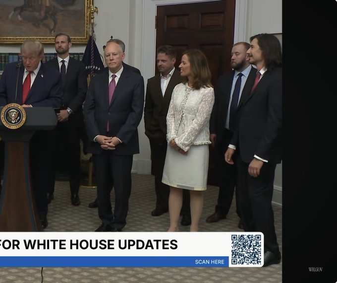 A news broadcast screenshot showing Donald Trump speaking at a podium in the White House with several people standing behind him, featuring a banner that reads 'WHITE HOUSE UPDATES' and 'SCAN HERE' with a QR code.