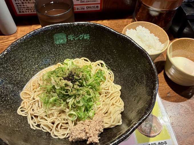A bowl of cold soba noodles topped with chopped green onions and ground meat, served with a side of grated daikon and dipping broth, likely at a King Seimen restaurant.