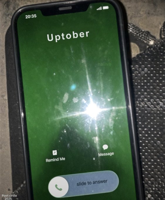 A smartphone displaying an incoming call screen with the caller name 'Uptober' and a green starry background, showing the time as 20:35 with options to 'Remind Me' or 'Message.'