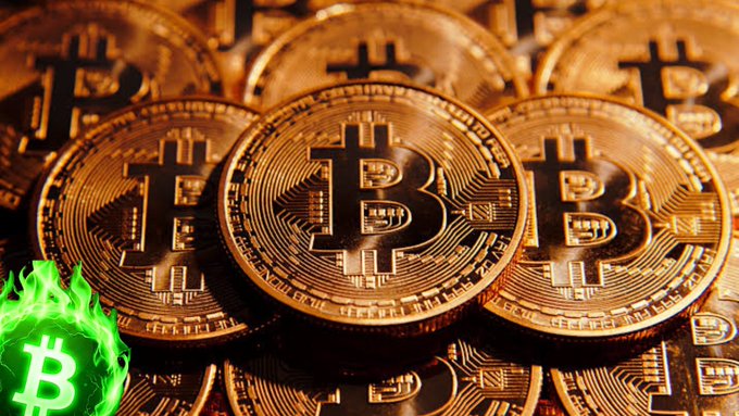 A close-up image of multiple physical Bitcoin tokens stacked together, with a green glowing Bitcoin logo superimposed in the bottom left corner.