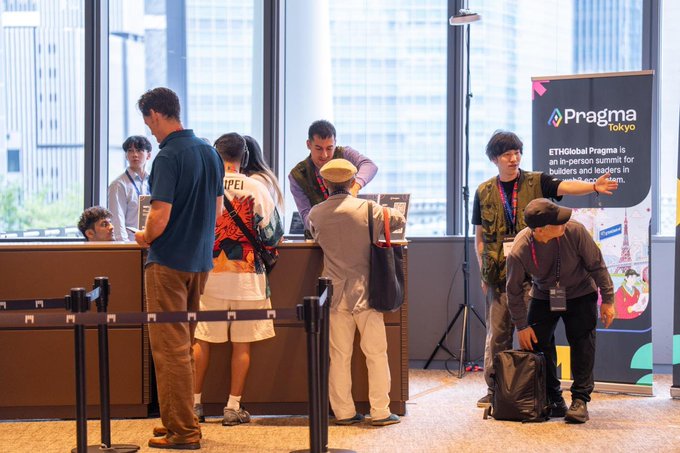 Attendees check in at a registration desk for ETHGlobal Pragma Tokyo, with a banner reading 'ETHGlobal Pragma is an in-person summit for builders and leaders in web3.'