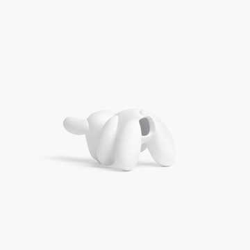 A minimalist, white sculptural figurine of a dog with simplified, rounded features and a short tail, isolated on a plain white background. The abstract, toy-like form visually evokes "dog mode" by capturing the playful essence of a canine in a stylized, modern design.