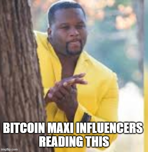 The image features a man wearing a yellow jacket leaning against a tree while typing on his phone. Below him, there's text that reads "Bitcoin Maxi Influencers reading this". The main focus of the image is the man with the keyboard, who appears to be engaged in an online conversation or browsing content related to Bitcoin and cryptocurrency.