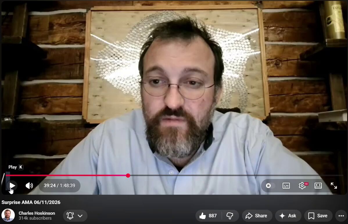 The image shows Charles, a bearded man wearing glasses, sitting at his computer with a webcam open in front of him. He appears to be engaged in an online meeting or video call. The caption below the image reads "Charles shares his thoughts on the Clarity Act".