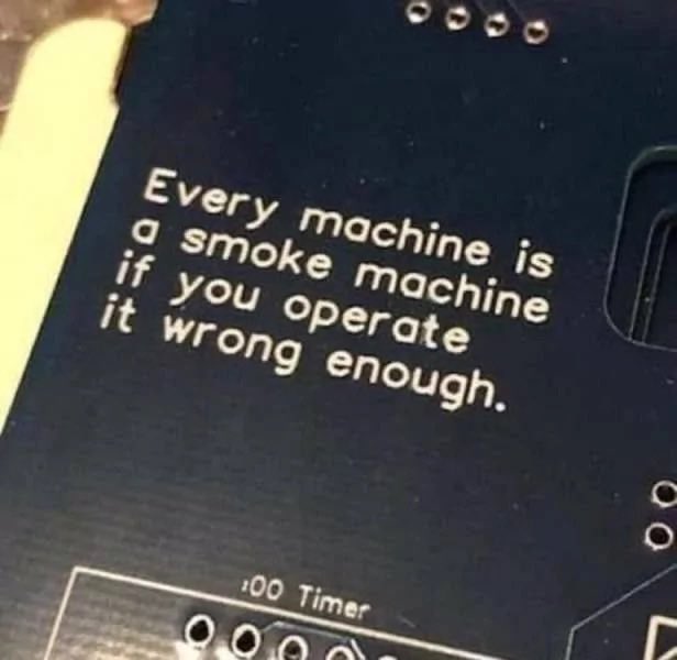 A close-up photo of printed text on a machine that humorously reads: "Every machine is a smoke machine if you operate it wrong enough."