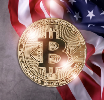 A golden Bitcoin physical commemorative coin resting on an American flag, featuring the iconic ₿ symbol design.