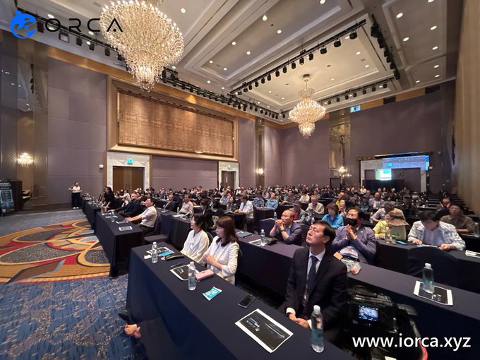 A large conference hall filled with seated attendees at long tables faces a presentation stage, where CEO Alex is speaking during the ORCA Global Roadshow event in Daegu. The watermark "iorca.xyz" and the "ORCA" logo are visible in the image corners, reinforcing the branded nature of the gathering.
