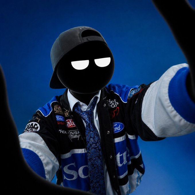 A stylized figure wearing a backwards cap and a NASCAR-style jacket featuring Ford, Brickyard Racing, and Steak 'n Shake racing patches takes a selfie against a blue background, with their face replaced by glowing white eyes—evoking the mysterious, larger-than-life persona of crypto influencers like ANSEM and CASHCAT, whose viral fame the post plays on.

Visible text includes "Ford," "Steak 'n Shake Racing," "Brickyard Racing," and a partial "sch" logo across the chest.
