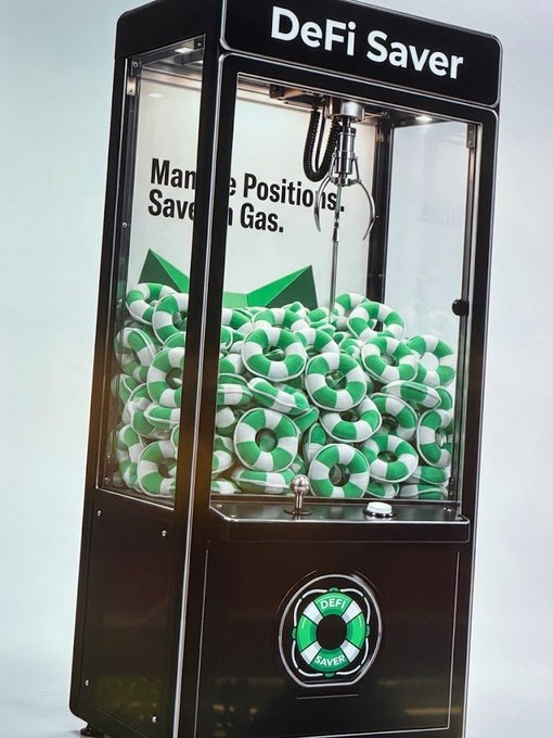 A 'DeFi Saver' claw machine filled with green and white tokens, featuring text that reads 'Manage Positions, Save on Gas.'