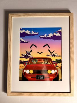 A framed pixel-art print displayed on a wall depicts two figures in a red car driving down a desert highway at sunset, with the license plate reading "MKC" and a small "X" signature in the corner. The artwork ties into the MAYC birthday celebration, as the post notes the owner hangs their "TJ art"—referring to this nostalgic, retro pixel-style piece featuring the iconic road-trip scene.