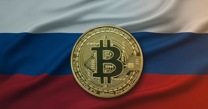 A gold Bitcoin coin overlaid on a waving Russian flag (white, blue, and red horizontal stripes).