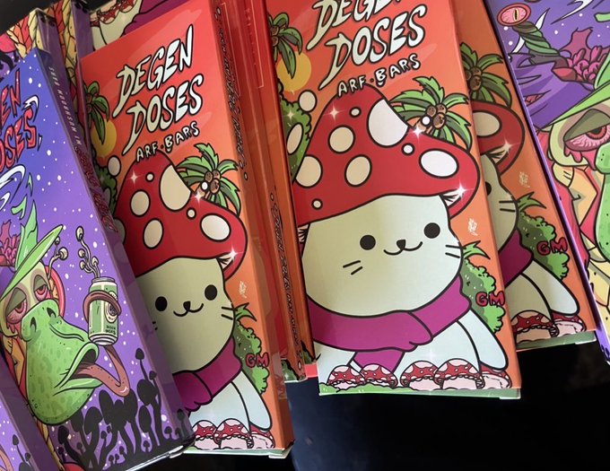 Multiple boxes of "Degen Doses Arf Bars" are displayed, featuring an adorable cartoon character with a red mushroom cap and a purple scarf against a colorful psychedelic background. The whimsical, eye-catching packaging ties into the post's playful "Gm degens" greeting and the tagline about bars keeping the rugs away, suggesting these treats are themed for crypto/web3 enthusiasts.