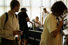 Attendees gather around an interactive demo station labeled "CHANGE HERE" at the Web3 Summit, where they test proof-of-concept apps developed by Parity and the Polkadot Community Foundation. The scene captures hands-on engagement with Web3 technology in a casual, lab-like environment.