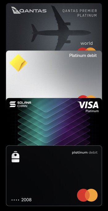 A digital wallet screenshot showing a Qantas Premier Platinum Visa debit card on the Solana Chain alongside an IB platinum debit Mastercard.