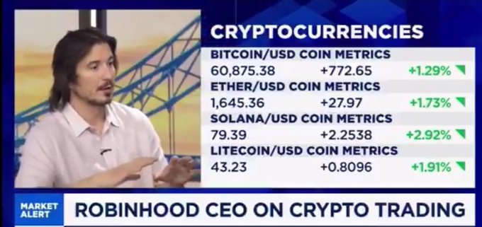 A news broadcast clip shows Robinhood CEO Vlad Tenev being interviewed alongside a "CRYPTOCURRENCIES" data board displaying live coin metrics for Bitcoin (60,875.38, +1.29%), Ether (1,645.36, +1.73%), Solana (79.39, +2.92%), and Litecoin (43.23, +1.91%), with a lower-third banner reading "MARKET ALERT: ROBINHOOD CEO ON CRYPTO TRADING." The image visually anchors the post's headline by setting the scene of Tenev's on-air appearance where he discusses the future of crypto trading, tokenization, and real-world assets on Robinhood's platform.