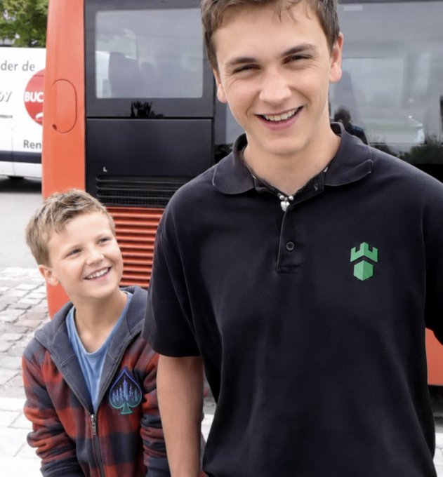Two smiling boys pose in front of an orange bus, with partial text "der de" and "BUCH" visible on a white sign behind them. The image appears to be a casual candid photo of the brothers, likely submitted as a real-life alternative to AI-generated portraits for the "Best AI picture" contest mentioned in the post.
