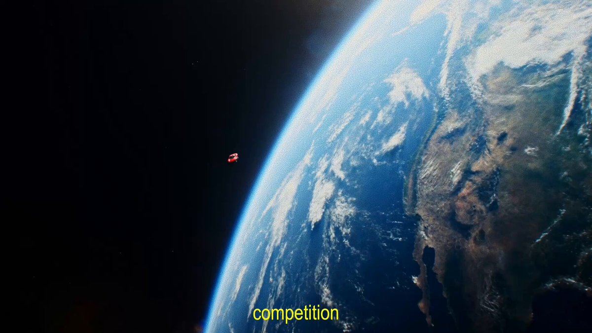The image shows a planet with a red object, possibly a satellite or space shuttle, flying over its surface. The caption above the image reads "Competition" which suggests that there might be some sort of competition taking place between different planets or celestial bodies in the solar system.
