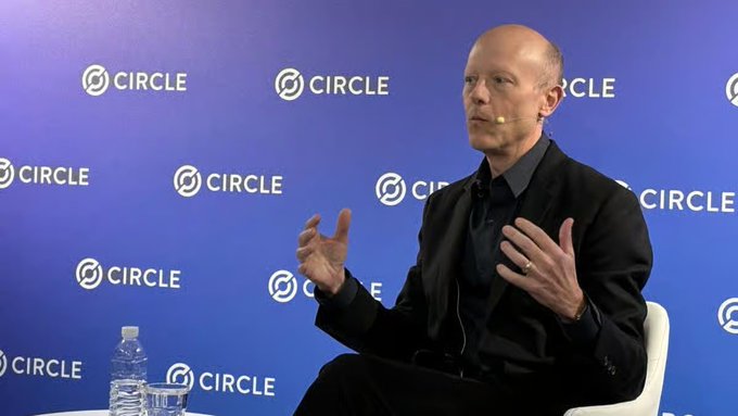 Circle CEO Jeremy Allaire speaks at a Circle-branded event, gesturing with his hands while wearing a headset microphone, illustrating his announcement that USDC stablecoin is expanding into roughly 50 emerging markets across Southeast Asia, Latin America, and the Middle East as part of a strategic push toward mass adoption.