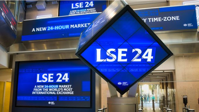 The image shows a London Stock Exchange (LSE) display promoting "LSE 24," a new 24-hour market from the world's most international exchange, reflecting how the traditionally stock-based exchange is adopting the 24/7 trading model pioneered by cryptocurrency markets.