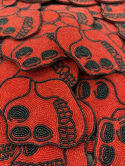 Red beaded patches with black skull-and-crossbones designs, likely clothing appliques or patches.