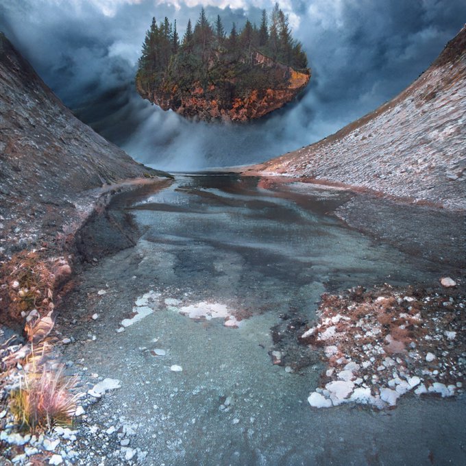 A surreal landscape featuring a floating island with pine trees above a partially frozen river under a cloudy sky.