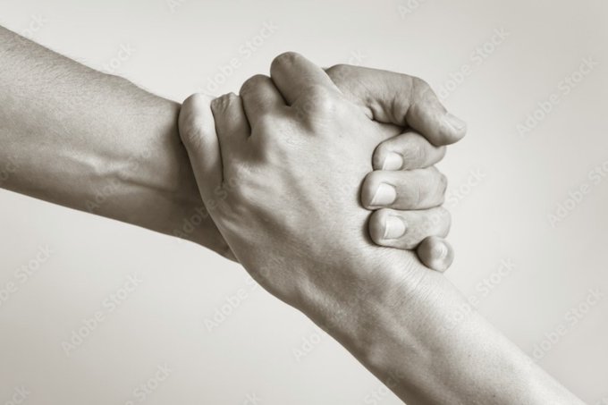 A black-and-white stock photo (Adobe Stock) showing two hands clasped together in a firm handshake or grip.