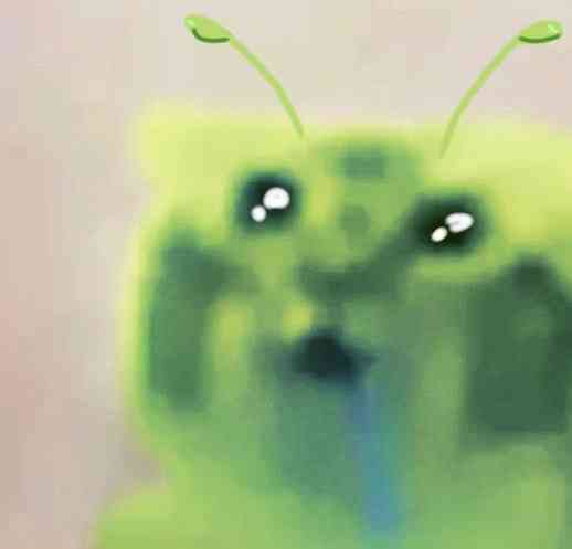 A blurry, green cartoon character with antennae and large, teary eyes, appearing sad or emotional.