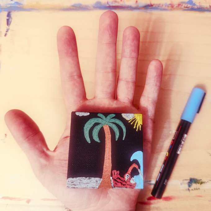 The image features a hand holding up a small palm-sized painting of a tree, with a blue marker next to it. The painting appears to be done by @YinYangYoeshi, who has posted their artwork on social media. The post includes a caption that reads "I have just collected Palm Sized Tree" and the artist's name "@YinYangYoeshi".