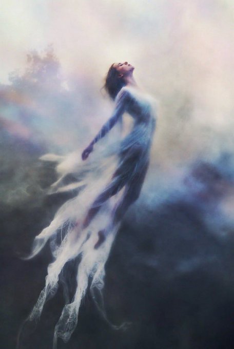 An ethereal digital painting of a woman in a flowing white dress floating upward against a misty, dreamlike sky with soft pastel colors.