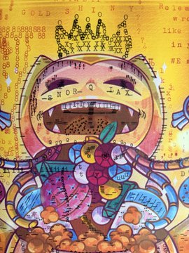 A colorful pop-art style mixed media artwork featuring a crown, an open mouth with teeth, abstract shapes, and text elements on a golden yellow background.