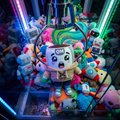 A vibrant collage featuring numerous cartoon characters arranged around a central figure, with colorful light beams radiating outward in the background.